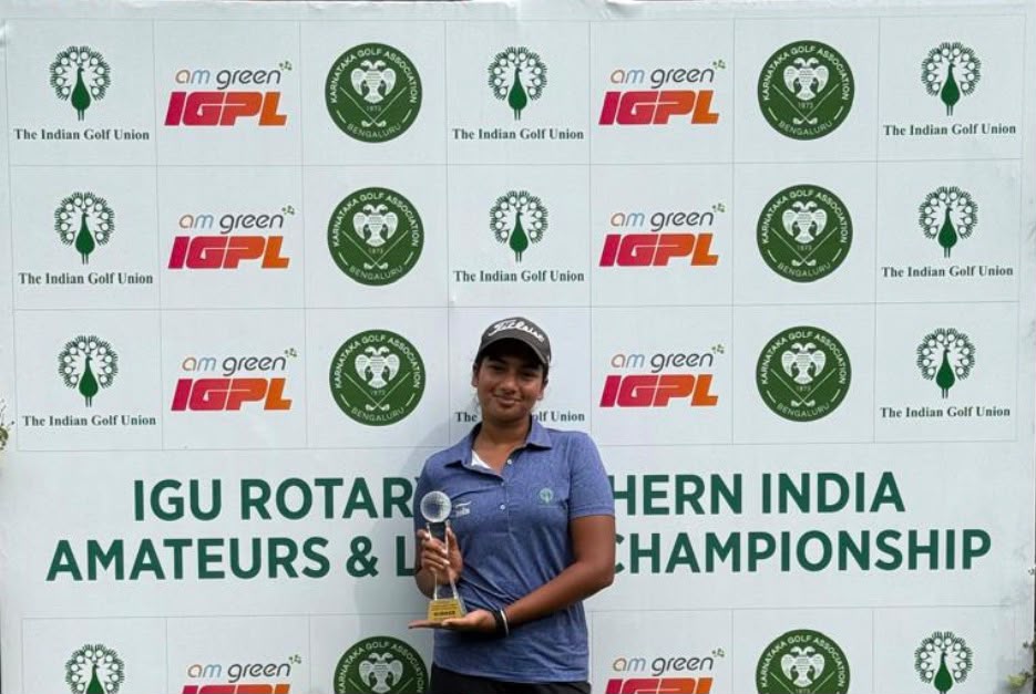Golfer holding a trophy in front of the Southern India championship backdrop at Karnataka Golf Association