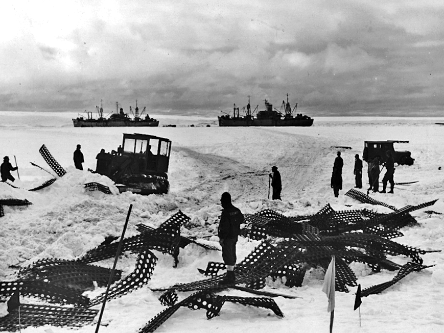 Bulldozer and supply ships during Operation Highjump in Antarctica.